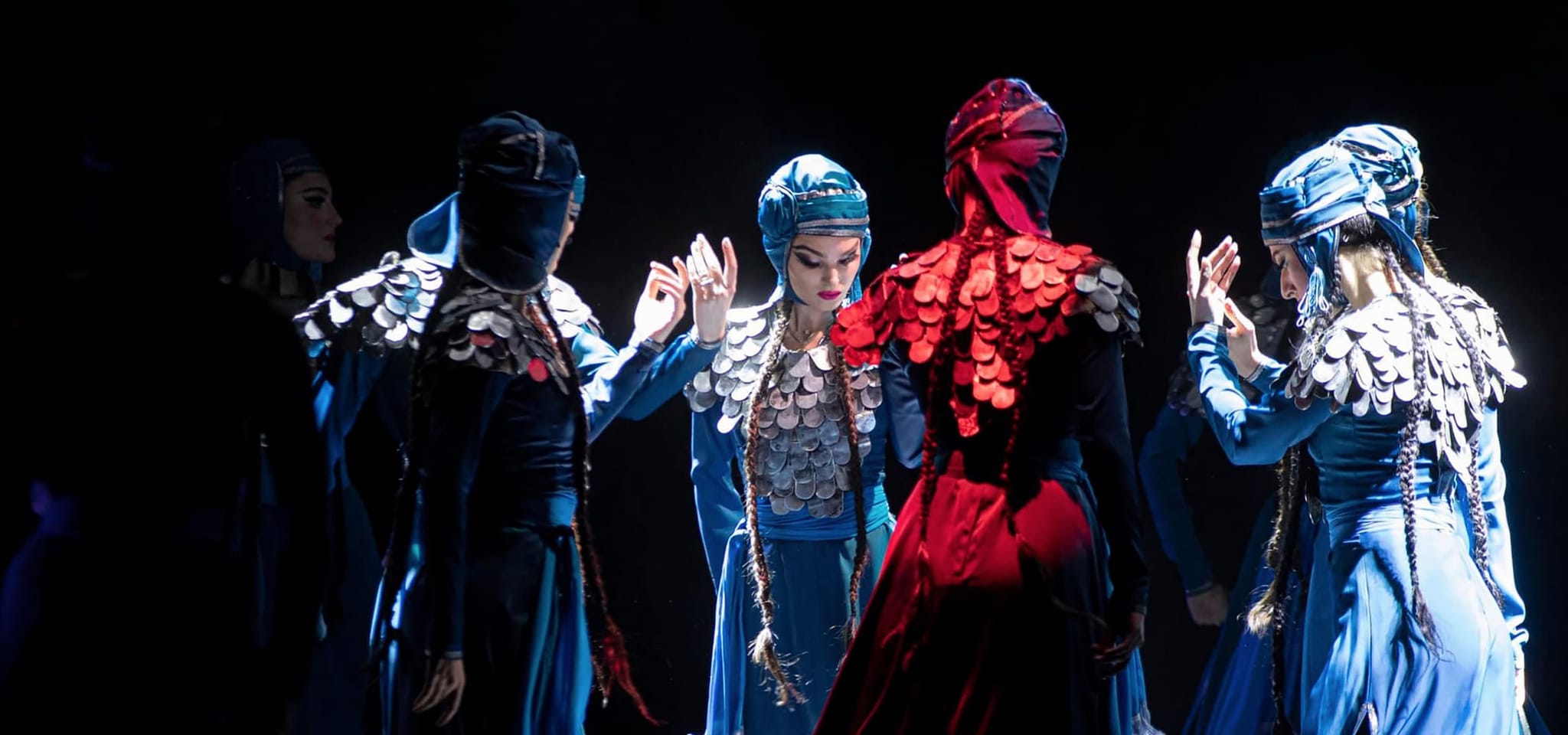 Dancers in blue and red costumes with beaded headdresses