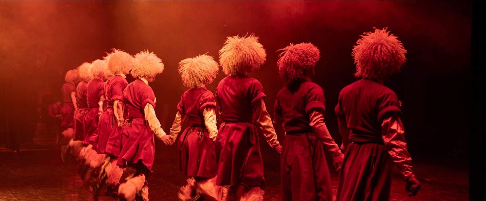 Sukhishvili dancers seen from behind under red stage light